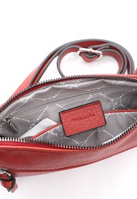 Rød læder crossbody taske med en struktureret overflade. Indvendigt har den en lynlåslomme og et logo-tag mod et mønstret gråt fôr.