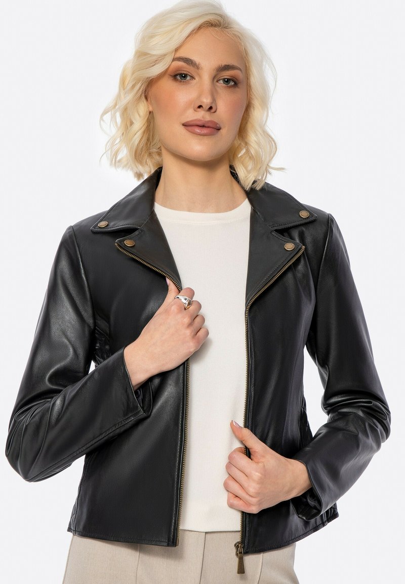 Schwarze Kunstleder-Motorradjacke mit Spitzkragen, Reißverschluss vorne und metallischen Hardware-Akzenten, die eine taillierte Passform und eine glatte Textur aufweist.
