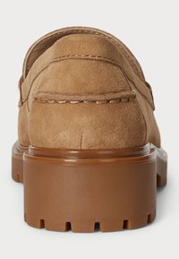 Suede loafers in tan with a chunky brown rubber sole. Features stitching along the upper edge and a flat back design.