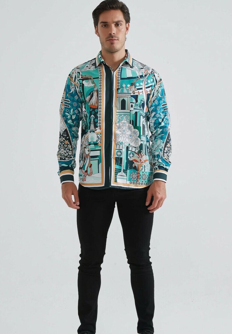 Homme debout portant une chemise à manches longues avec des motifs architecturaux et floraux multicolores et un pantalon noir.