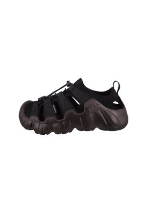 Zwarte waterdichte outdoorsandaal met gesloten teen, verstelbare bungee veters en robuuste zool, ontworpen voor bescherming en comfort.