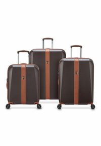 Tre valigie rigide di colore marrone scuro con accenti marrone chiaro, dotate di manici estraibili, cerniere e quattro ruote ciascuna.