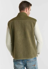 Fleece-Weste mit olivgrünem strukturierten Rücken und Schultern, cremefarbenen Ärmeln und einem Kragen. Verfügt über einen lässigen Schnitt und ein entspanntes Design.