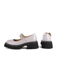 Chaussures Mary Jane rose clair brillantes avec des brides à boucle dorée et des semelles compensées noires épaisses, vues de côté et de dos.