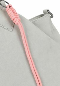 Grijze faux leren tas met een gestructureerd oppervlak, voorzien van een roze gevlochten trekkoord en metalen hardware. Compact en modern ontwerp.