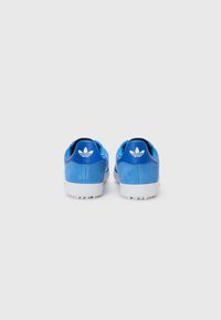Baskets en suède bleu avec semelles en caoutchouc blanches et accents noirs. Dotées d'un logo à trois feuilles sur le talon et d'un design bas.
