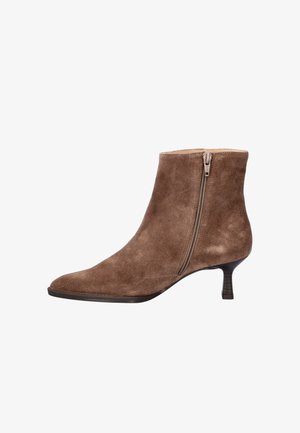 Bottine en suède marron avec un bout pointu, une fermeture éclair latérale et un petit talon empilé. Texture lisse avec un design minimaliste.