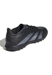 Black athletic shoes with a mesh upper, featuring silver accent stripes and a textured design. Includes logo and lightweight rubber sole.