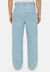 Pantalones de mezclilla azul claro con un ajuste relajado, que cuentan con dos bolsillos traseros y un bolsillo lateral, terminados con pasadores para cinturón y un sutil logo de la marca.