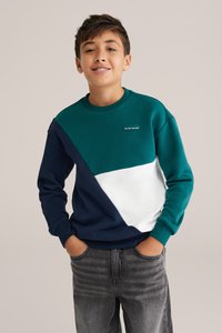 Zaļa, tumši zila un balta krāsu bloku džemperis ar apaļu kakla izgriezumu un logotipa detaļu. Izgatavots no kokvilnas maisījuma, iekļaujot ribotas aproces.