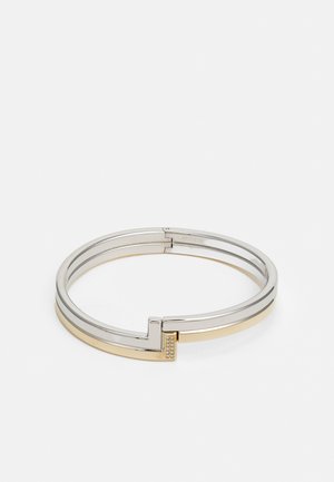 Bracciale rigido in metallo argento e oro dal design elegante, dotato di una chiusura e piccole pietre di strass sui lati.