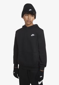 Sweat-shirt noir avec le logo Nike blanc sur la poitrine, associé à un bonnet en tricot noir et des gants, tous deux arborant le même logo. Texture lisse.