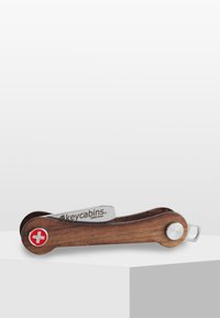 Trämultifunktionellt verktyg med silvermetallaccenter, med en röd emblem. Designen är elegant, med en hopfällbar form och en mjuk textur.