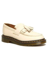 Scarpa in pelle color crema con design mocassino, caratterizzata da dettagli frangiati e una robusta suola in gomma nera con accenti di cucitura arancione.