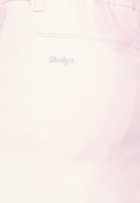 Ljusrosa shorts i mjukt tyg, med en broderad "Daily"-logga på fickan och en platt midjeresår med knappstängning.