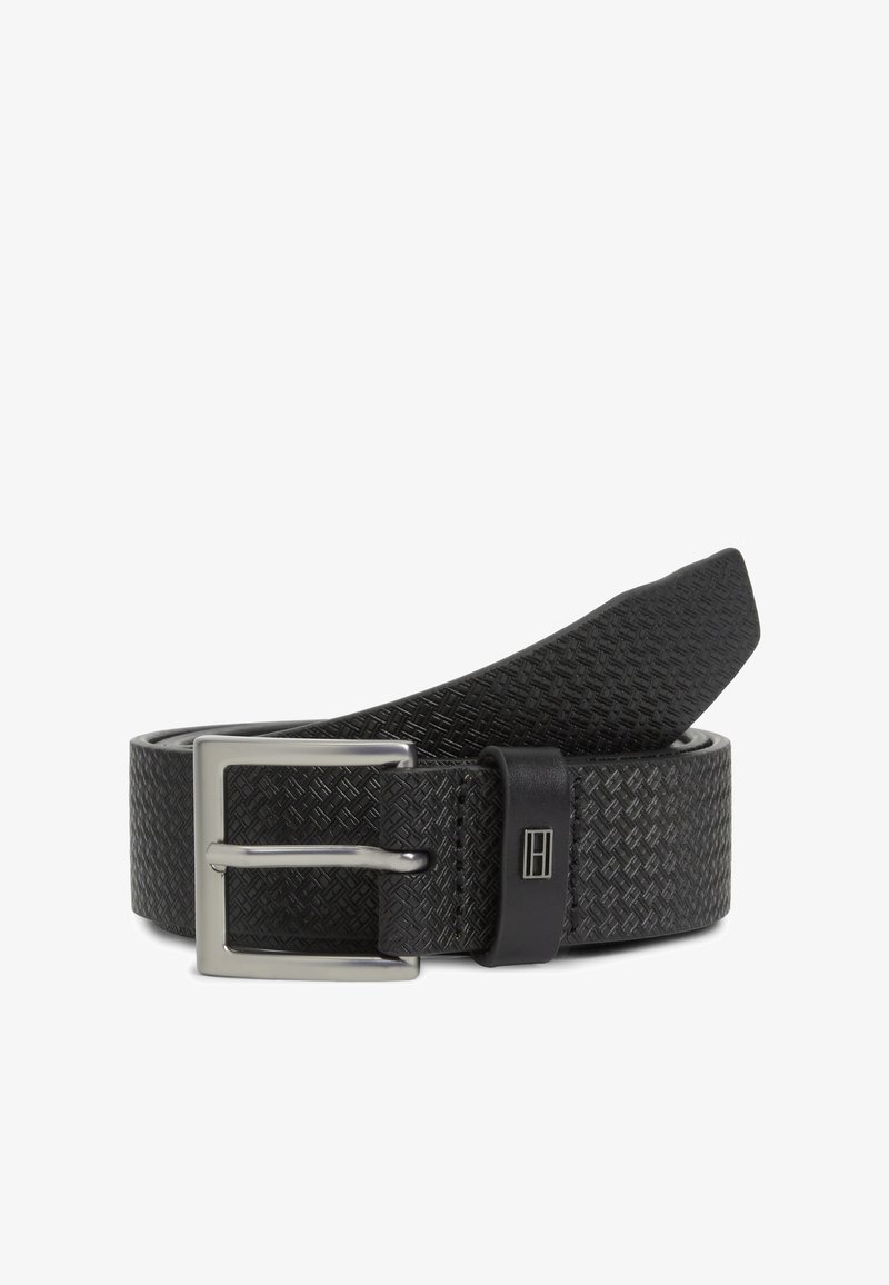 Μαύρη πλεκτή ζώνη με υφασμένη επιφάνεια, ασημί μεταλλική αγκράφα και μαύρη δερμάτινη λεπτομέρεια κοντά στην αγκράφα.