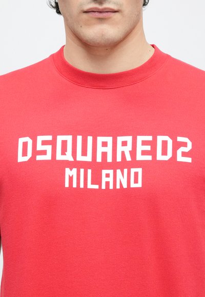 Punane puuvillane t-särk, millel on eest valgete plokk-tähtedega kiri "DSQUARED2 MILANO". Klasikalise ümarkaelusega.