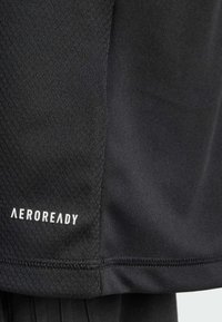 Pantalones cortos deportivos negros de tejido con un patrón texturizado. Presenta el logo "AEROREADY" en texto blanco en el dobladillo. Detalle de costura suave.