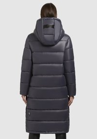 Mantou lung, de culoare gri închis, tip puffer, cu glugă. Design cu cusături orizontale și o textură lucioasă și netedă. Prezintă un logo pe spate și buzunare laterale.