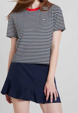 Stribet bomulds t-shirt med rød rund hals, med navy og hvide vandrette striber og et lille logo. Sammen med en navy flared nederdel.