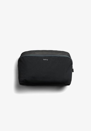 Pochette compacte noire Bellroy avec fermeture éclair et panneau supérieur en maille, conçue pour organiser de petits objets personnels.
