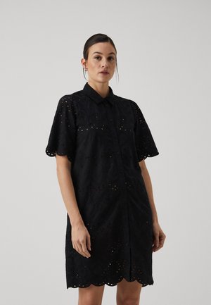 Black button-up dress with short scalloped sleeves, eyelet embroidery, textured fabric, and a straight silhouette, reaching mid-thigh.