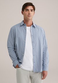 Blau-weiß kariertes Hemd aus leichtem Stoff, mit Knopfleiste, langen Ärmeln und lockerer Passform über einem weißen T-Shirt.