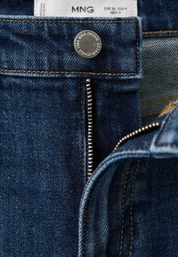 Tmavě modré džíny z denimu s částečně otevřeným kovovým zipem, kovovým knoflíkem s logem "MNG Denim Established 1984" a štítkem s velikostí EUR 36, USA 4.