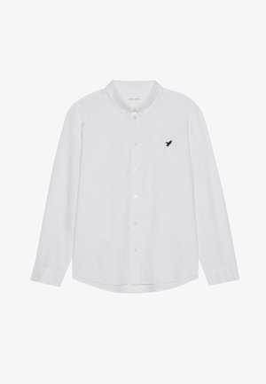 Biela košeľa s dlhým rukávom a gombíkmi vyrobená z bavlnenej tkaniny. Má čiernu vyšívanú vtáčiu aplikáciu na ľavej hrudi a golier s gombíkmi.