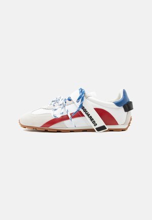 White sneaker with red side stripe, blue heel tab, blue and white laces, and white strap labeled "SQUARED2" on gum sole.