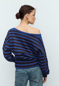 Preveliký sveter s modrými a hnedými horizontálnymi pruhmi. Mäkká pletená textúra s dizajnom s klesnutými ramenami a širokým výstrihom.