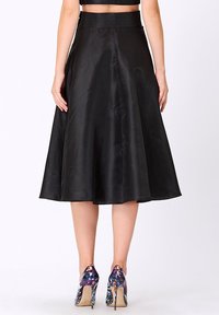 Jupe midi en satin noir avec un design évasé et une texture lisse ; dotée d'une taille ajustée et tombant élégamment en dessous du genou.