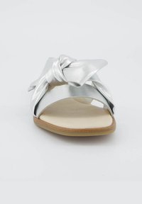 Silberne Leder-Slidesandalen mit einem geknoteten Bogen-Design, offenem Zehenbereich und einer beigen gepolsterten Innensohle mit einer hellbraunen Gummisohle.
