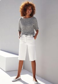 Grijze gebreide top met korte mouwen, witte denim bermuda shorts, zilveren riem en metallic flats. Glad textuur, ontspannen pasvorm, casual outfit.