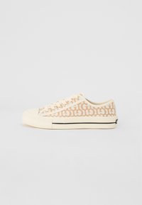 Canvas-sneakers i krämfärg med ett beige geometriskt mönster, gummitå, och strukturerad sula, som har sex hål för snören.