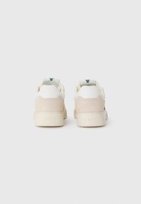 Sneaker con parte superiore in pelle bianca e dettagli in suede beige, con un logo teal sul tallone e una suola in gomma testurizzata.