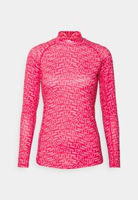 Långärmad, höghalstablett i klargul med ett heltäckande vitt labyrintliknande geometriskt mönster och figurnära siluett.