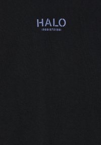 Czarna tkanina z napisem "HALO" w jasnofioletowym kolorze nad numerami "1968 | 1972 | 1981" w mniejszym tekście.