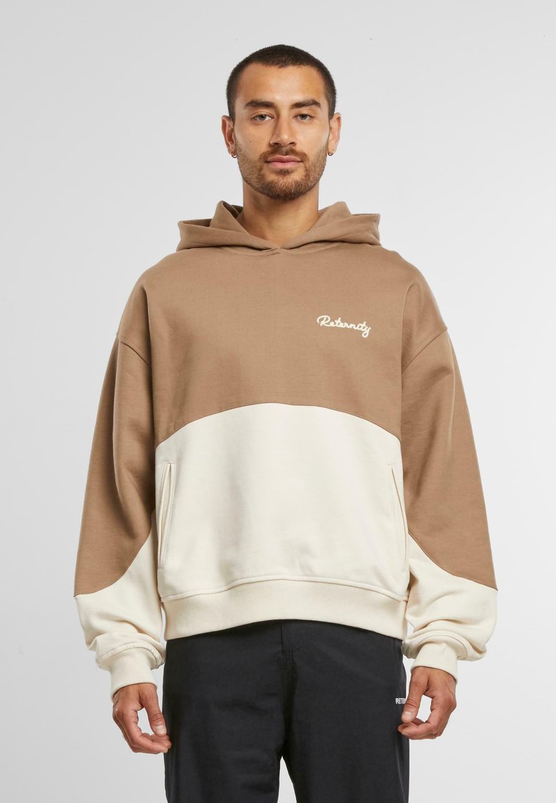 Brun og kremfarget fargeblokkert hettegenser med frontlomme, snorhette og brodert "Reternity"-logo på brystet. Myk tekstil.