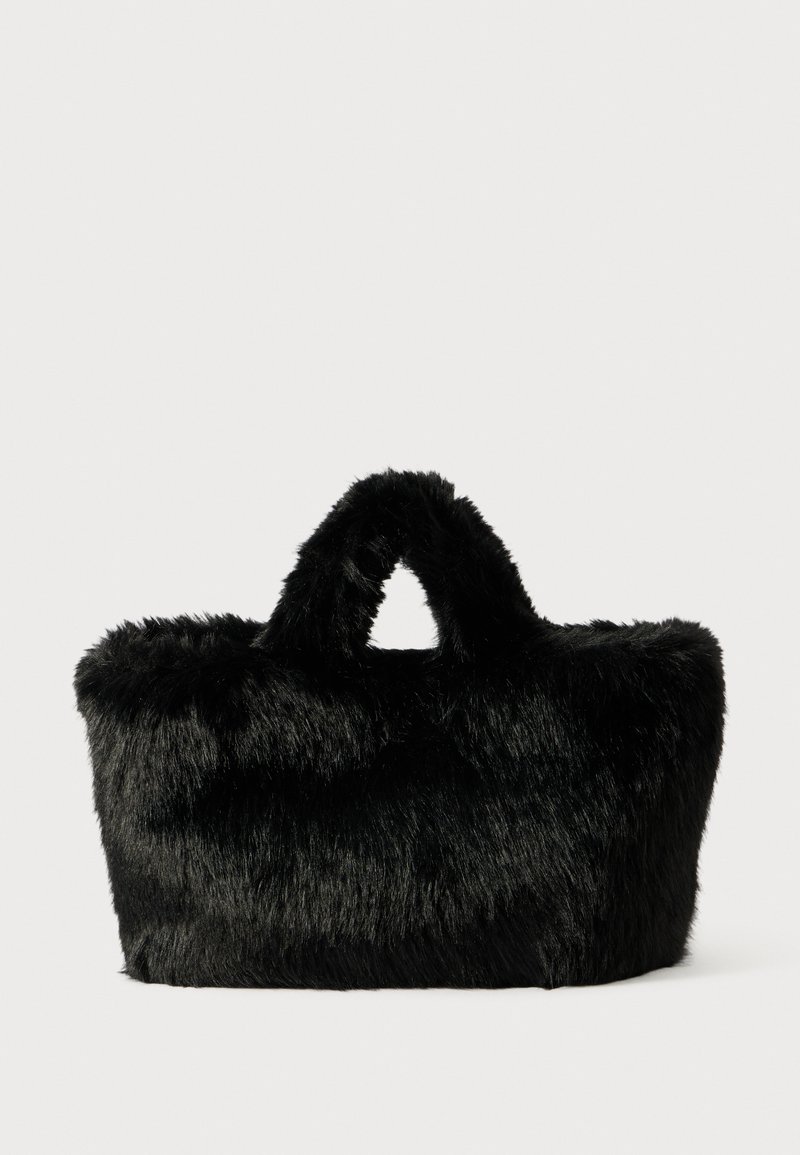 Bolso de piel sintética negra con una parte superior redondeada y dos asas cortas. Exterior suave y texturizado con una forma estructurada. Sin herrajes visibles.