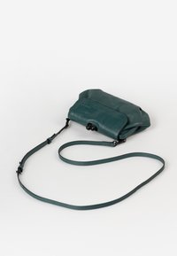 Borsa a tracolla in pelle verde acqua con una struttura morbida, tracolla regolabile, dettagli in metallo arrotondati e design con patta pieghevole.