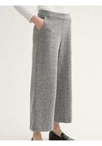 Grijze herringbone wijde broek, met zijzakken en een comfortabele tailleband, gecombineerd met zwarte instappers.
