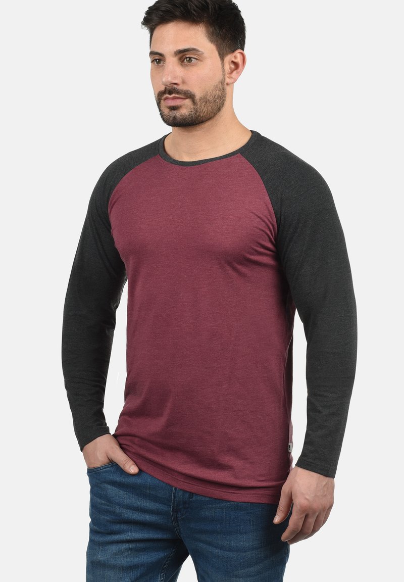 Majica dugih rukava raglan kroja s bordo tijelom i tamnosivim rukavima. Napravljena od mekog materijala s klasičnim okruglim izrezom.