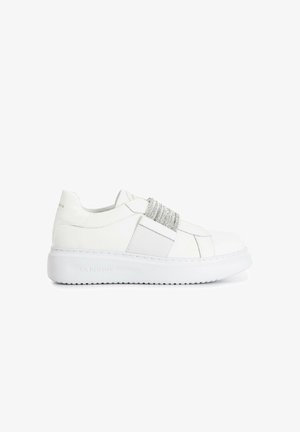 Baskets en cuir blanc avec une bande élastique texturée en argent sur le devant du pied ; dotées d'une épaisse semelle blanche et d'un logo de marque en relief à l'arrière.
