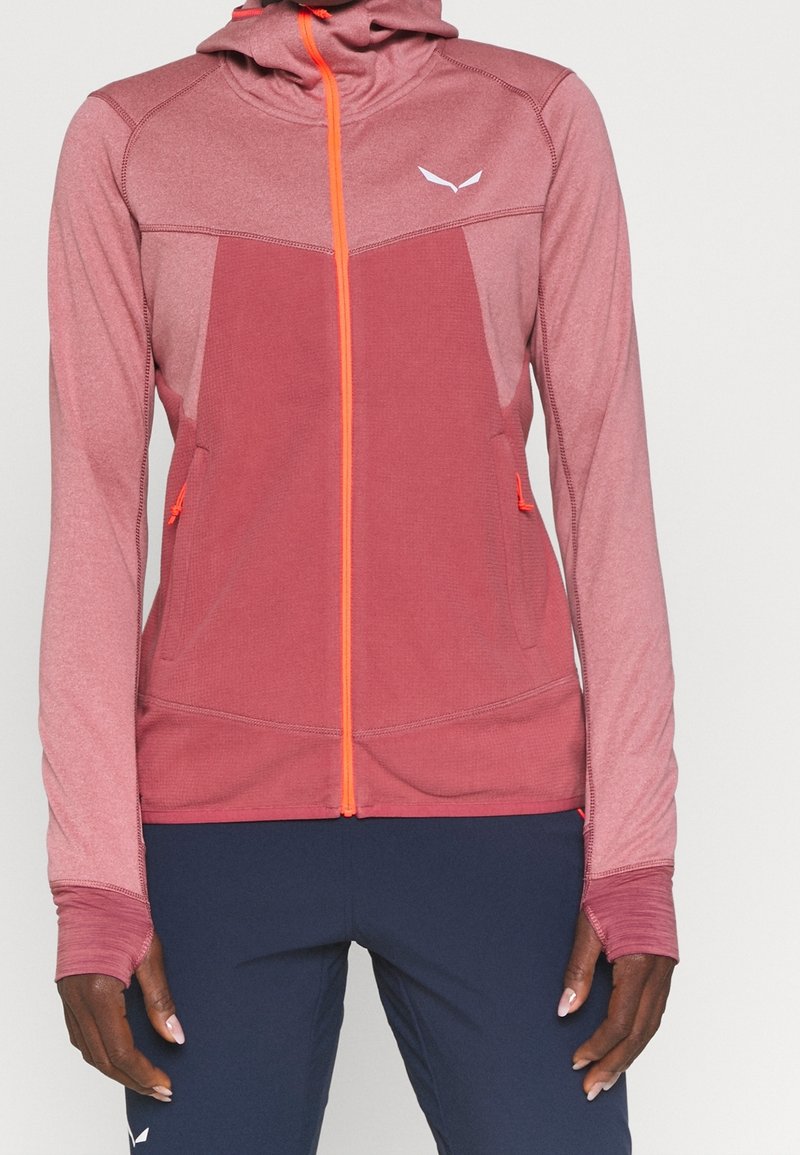 Huva, zip-up jacka i gradient rosa med orange dragkedja och detaljer. Har två framfickor och tummhål vid ärmslut. Mjuk, texturerad tyg.