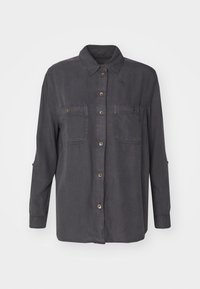 Mörkgrå skjorta med knappar och krage, två bröstfickor och möjlighet att rulla upp ärmarna. Tillverkad av mjukt tyg med en slät yta.