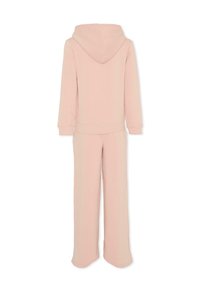 Completo loungewear rosa chiaro composto da una felpa con cappuccio con orlo a coste e maniche lunghe, abbinato a pantaloni a gamba larga coordinati.