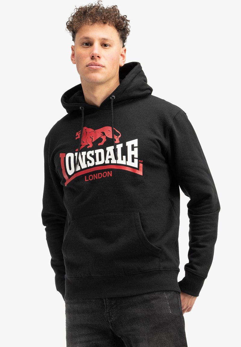 Sudadera negra con capucha y cordón, que presenta un gran gráfico de un león rojo y el texto "LONSDALE LONDON". Bolsillo frontal tipo canguro y puños acanalados.