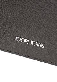 Portafoglio sintetico nero con texture, caratterizzato da un logo "JOOP! JEANS" in argento e bordi cuciti per garantirne la durata. Design compatto e rettangolare.