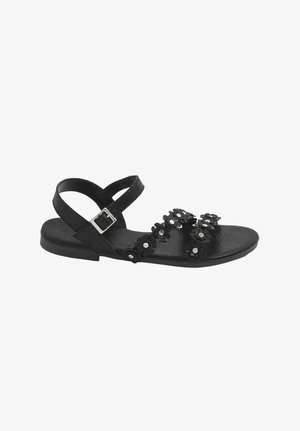 Sandalia plana negra con dos tiras decoradas con flores que cruzan el pie y una tira ajustable en el tobillo con hebilla plateada.
